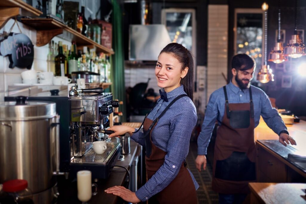 Come incrementare i guadagni di un bar con servizi innovativi 2 Come incrementare i guadagni di un bar: Bar Lady sorridente mentre prepara caffè